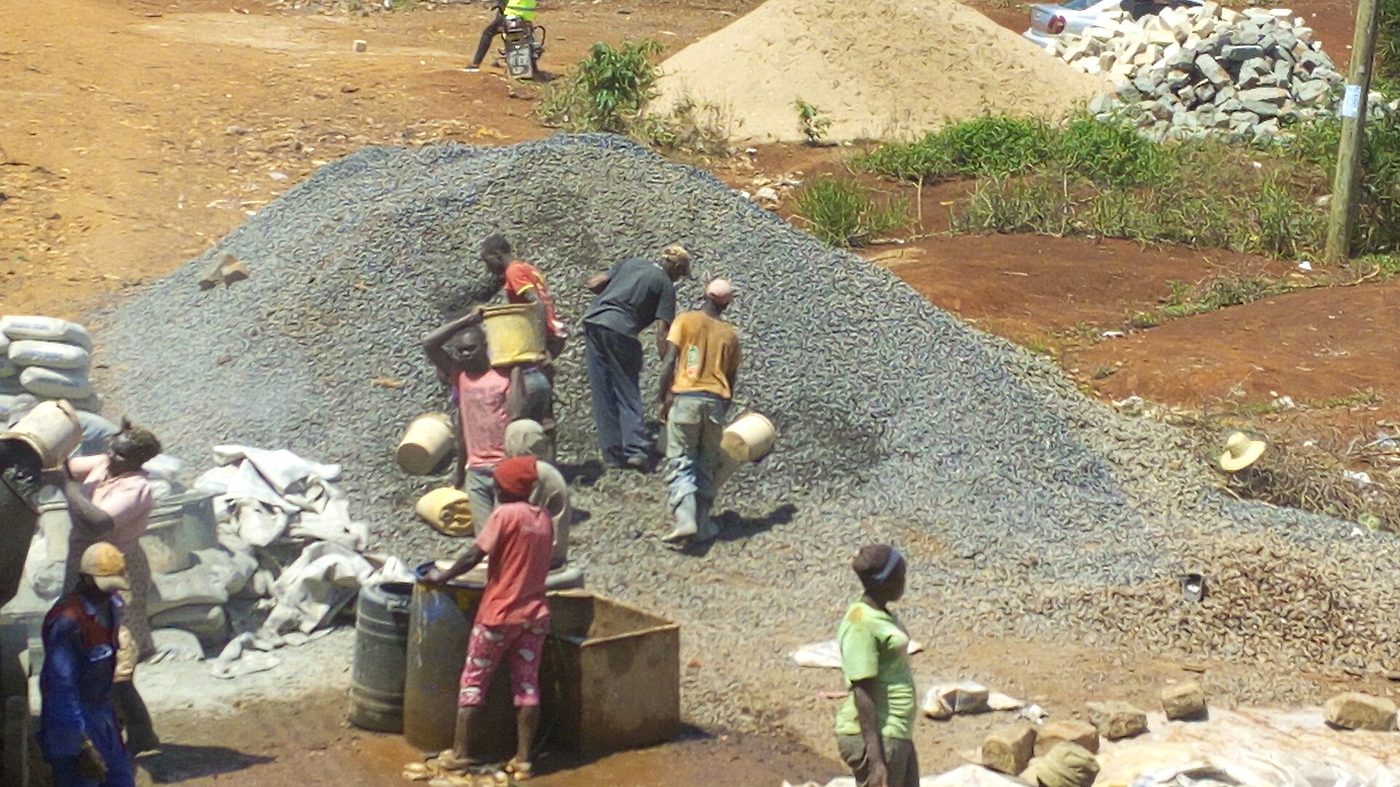 Workers batching ballast and cement on a site in Embu
